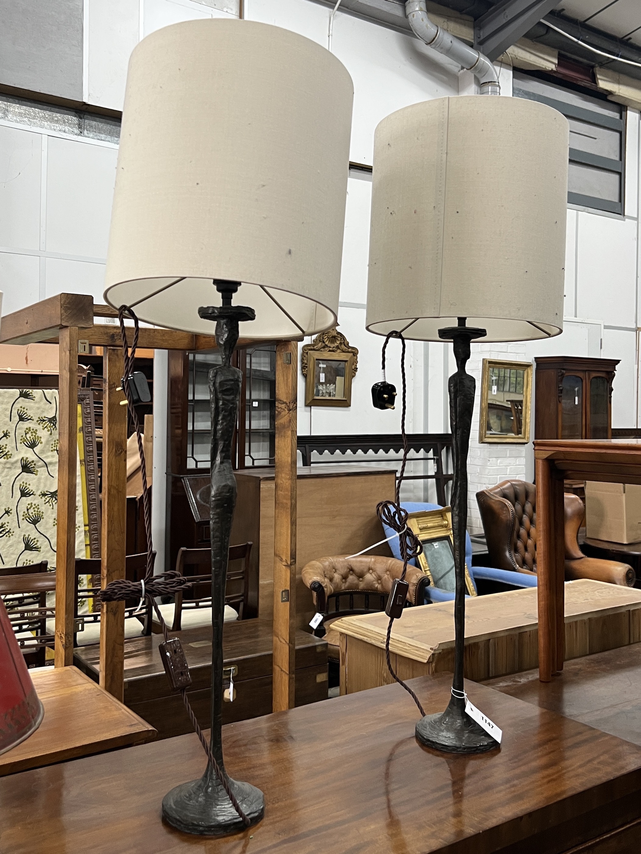 A pair of contemporary bronzed resin figural table lamps and shades, height including shades 97cm